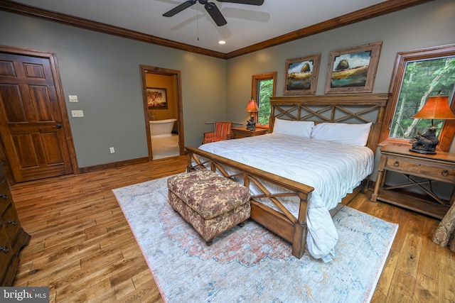 bedroom with connected bathroom, wood finished floors, a ceiling fan, baseboards, and crown molding