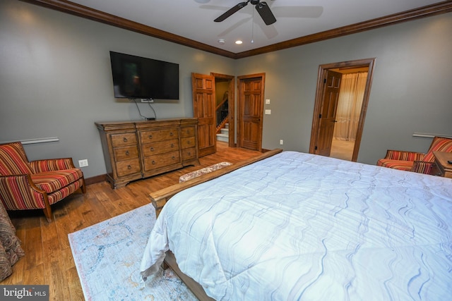 bedroom with crown molding, baseboards, ceiling fan, and wood finished floors