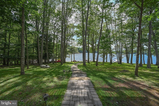 view of home's community with a water view and a yard