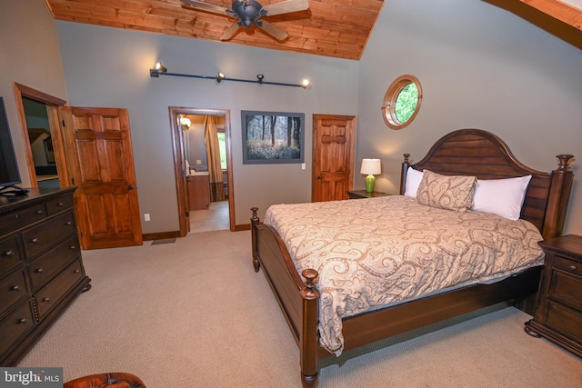 bedroom featuring light carpet, baseboards, wooden ceiling, ensuite bath, and high vaulted ceiling