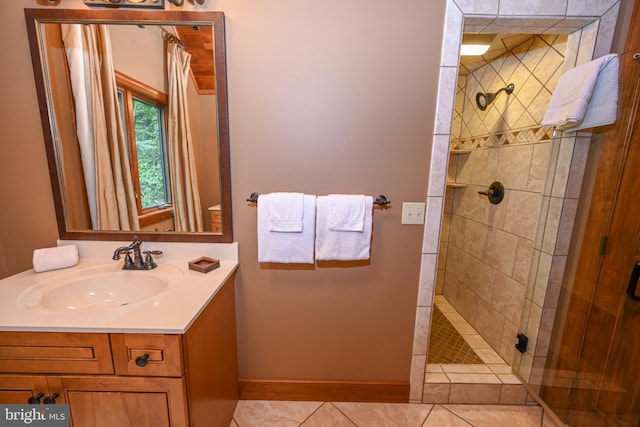 full bathroom with tile patterned flooring, a shower stall, vanity, and baseboards