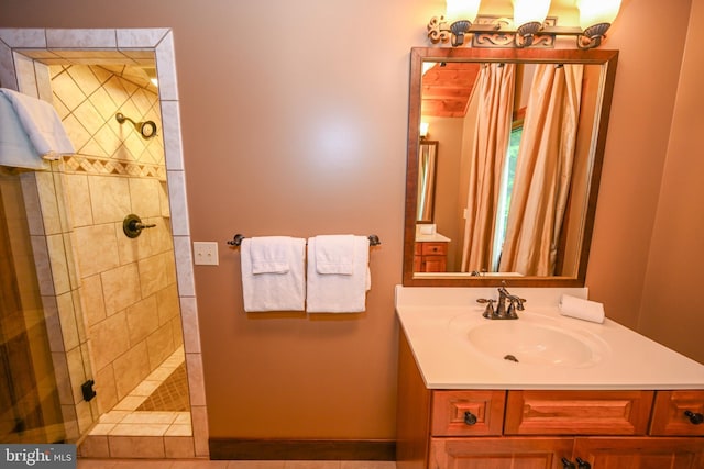 full bath featuring a tile shower and vanity