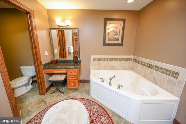 full bathroom with baseboards, toilet, tile patterned floors, a jetted tub, and vanity