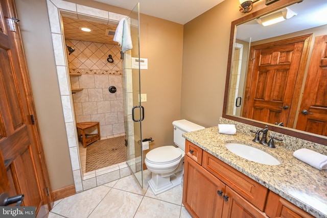 bathroom with baseboards, toilet, tile patterned floors, vanity, and a shower stall