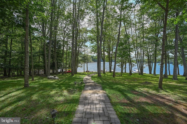 surrounding community featuring a lawn and a water view