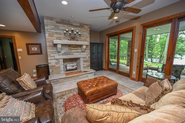 living room featuring ceiling fan, light tile patterned floors, and a stone fireplace