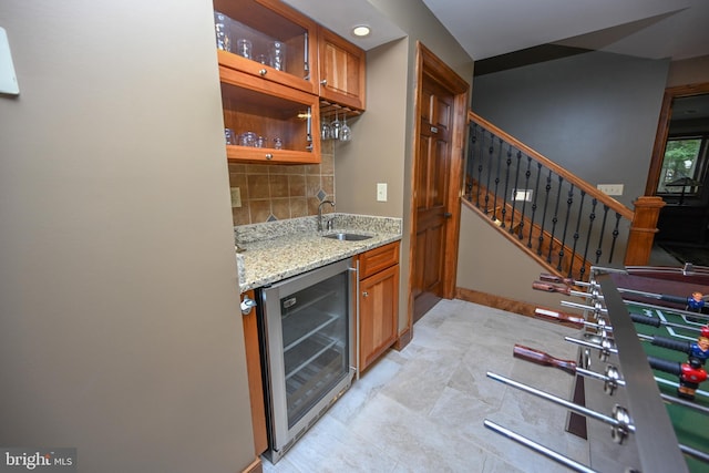 bar featuring beverage cooler, decorative backsplash, stairway, wet bar, and a sink