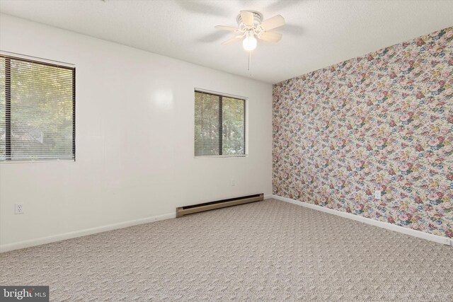 spare room featuring a baseboard radiator, carpet floors, and ceiling fan