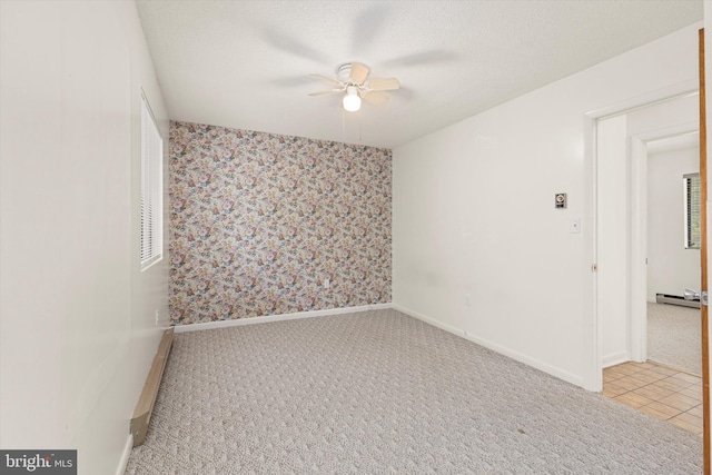 empty room with light carpet, a baseboard radiator, a textured ceiling, and ceiling fan