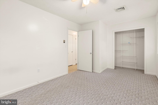 unfurnished bedroom featuring light carpet, ceiling fan, and a closet