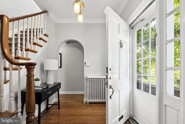 entryway with dark hardwood / wood-style flooring, crown molding, and radiator heating unit