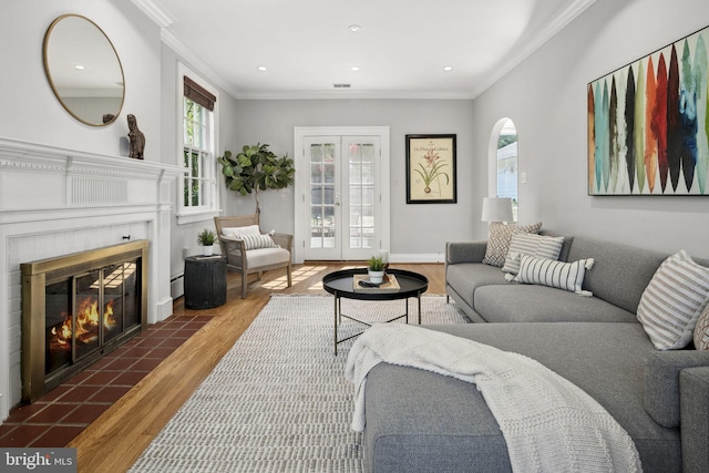 living room with dark wood-type flooring, a fireplace, french doors, and crown molding