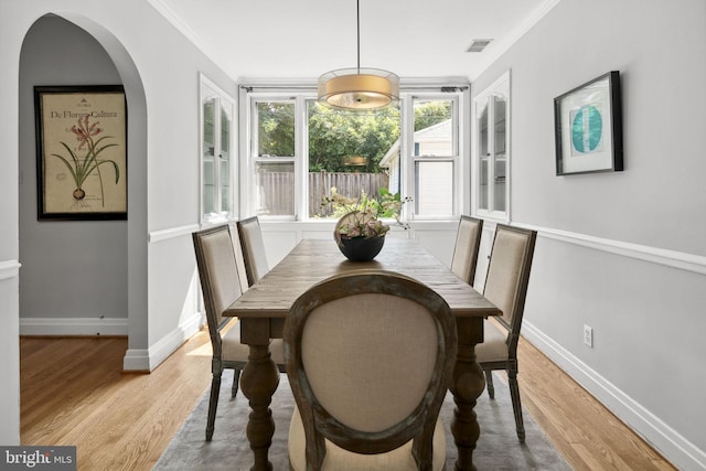 dining room featuring ornamental molding and light wood-type flooring