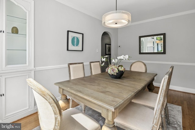 dining area featuring ornamental molding and light wood-type flooring