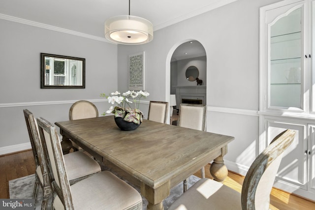 dining area with hardwood / wood-style flooring and crown molding