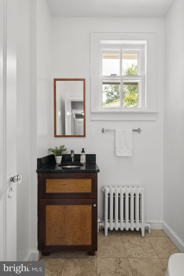 bathroom with vanity, radiator, and toilet