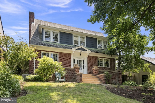 view of front of home with french doors and a front lawn