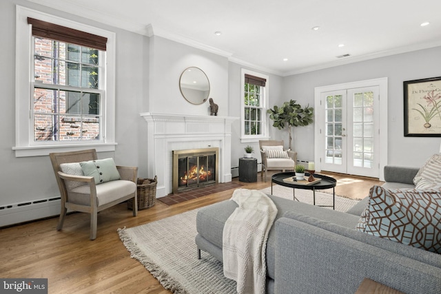 living room featuring crown molding, hardwood / wood-style flooring, french doors, and baseboard heating