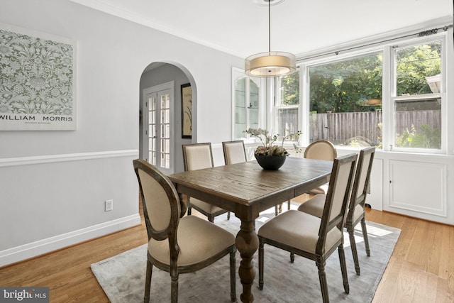 dining room featuring ornamental molding and light hardwood / wood-style flooring