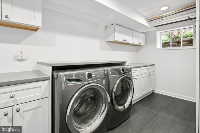 laundry area featuring cabinets, dark hardwood / wood-style floors, and washer and dryer