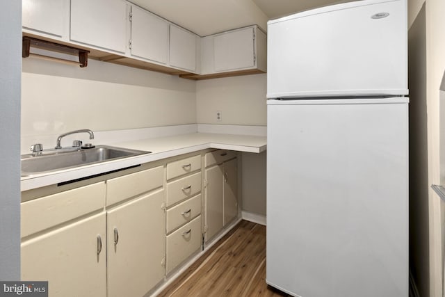 kitchen featuring white refrigerator, sink, and hardwood / wood-style floors