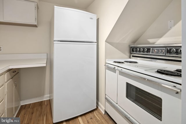 kitchen with white appliances, light hardwood / wood-style floors, and white cabinets