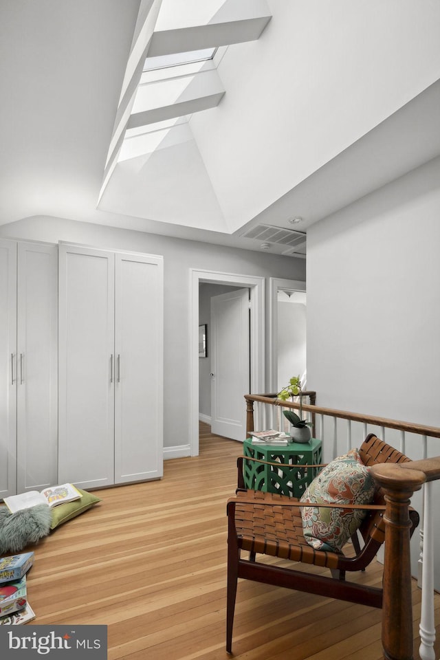 sitting room with vaulted ceiling and light hardwood / wood-style flooring