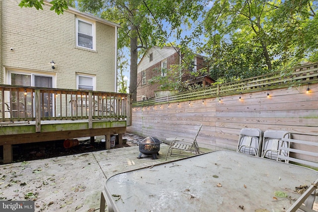 wooden terrace with a patio area and a fire pit