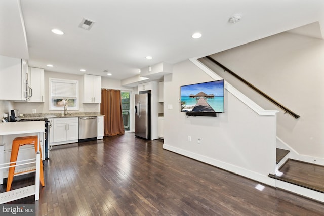 kitchen with white cabinets, appliances with stainless steel finishes, sink, and dark hardwood / wood-style floors