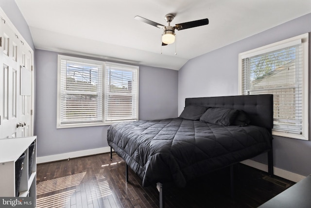 bedroom with ceiling fan, dark wood-type flooring, and vaulted ceiling