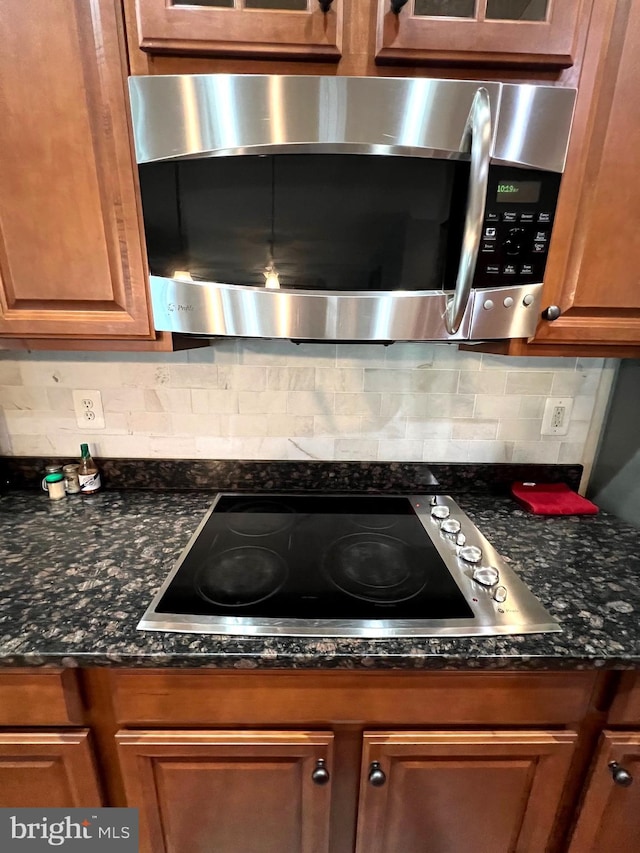 kitchen featuring tasteful backsplash, cooktop, and dark stone countertops