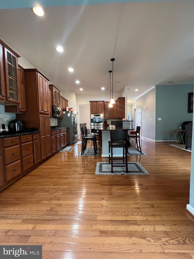 dining space with ornamental molding and light hardwood / wood-style floors