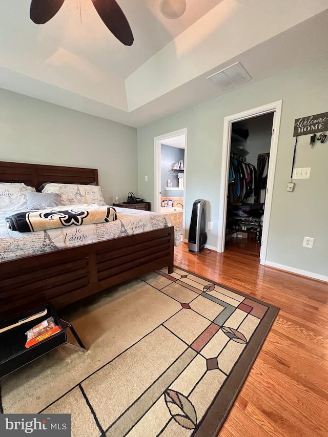 bedroom featuring wood-type flooring, a spacious closet, and ceiling fan