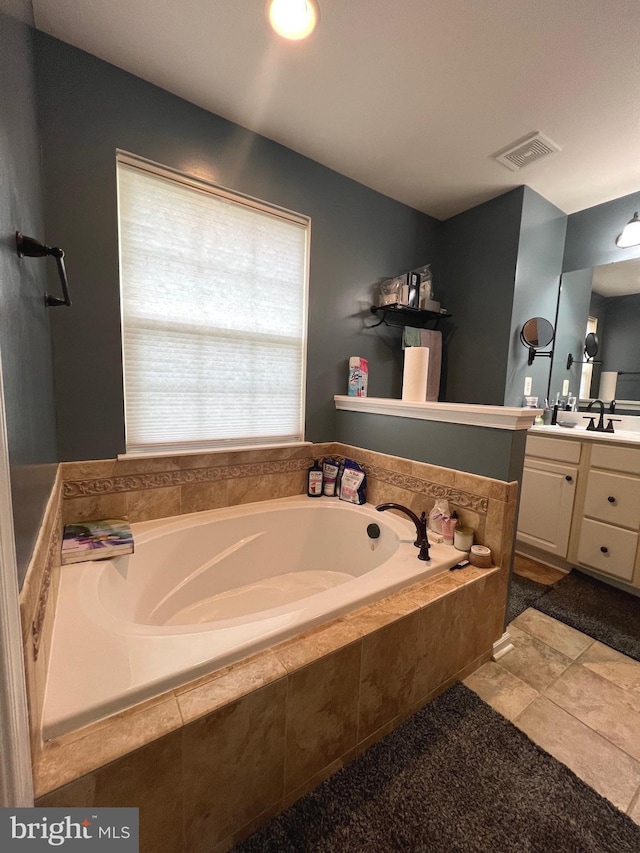 bathroom featuring vanity and tiled bath