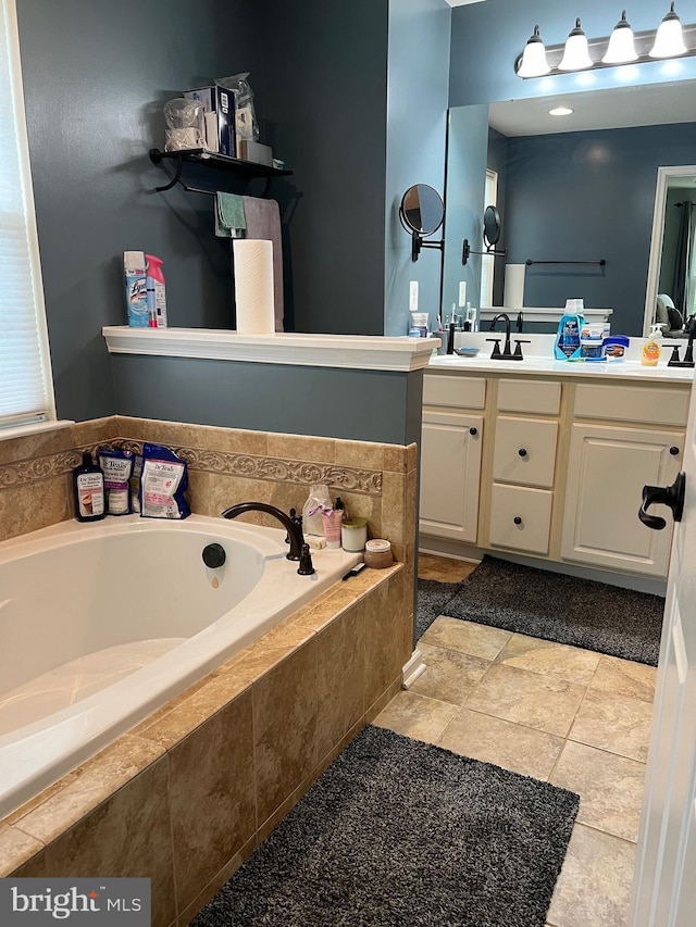 bathroom featuring vanity, tile patterned flooring, and tiled bath