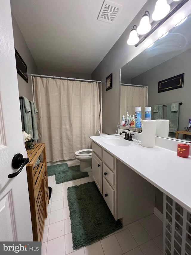 bathroom featuring vanity, tile patterned floors, and toilet