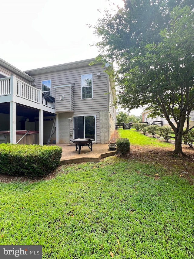 back of property with a yard, a patio area, and a balcony