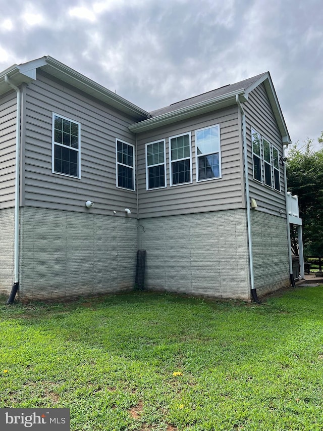 rear view of house featuring a yard