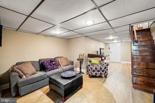 living room featuring a drop ceiling and light hardwood / wood-style flooring