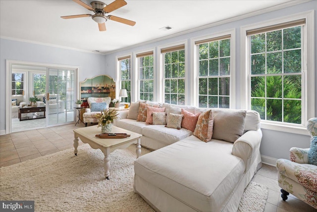 sunroom / solarium with light tile patterned flooring, ceiling fan, and crown molding