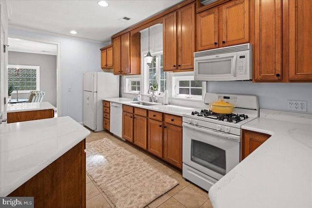 kitchen with sink, a wealth of natural light, white appliances, and light stone counters