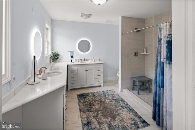 bathroom featuring tile patterned flooring, toilet, walk in shower, and vanity