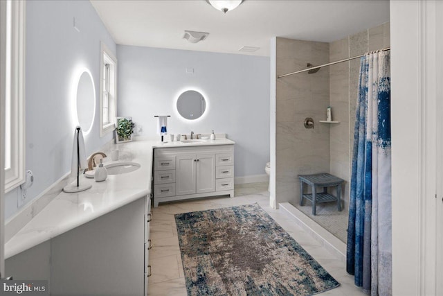 bathroom featuring toilet, vanity, and curtained shower