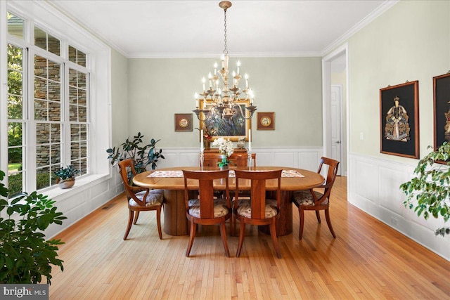 dining room with plenty of natural light, an inviting chandelier, light hardwood / wood-style floors, and crown molding