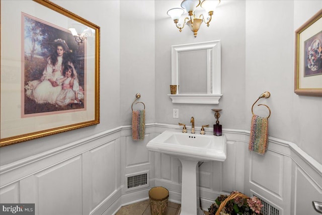 bathroom with a notable chandelier and tile patterned floors