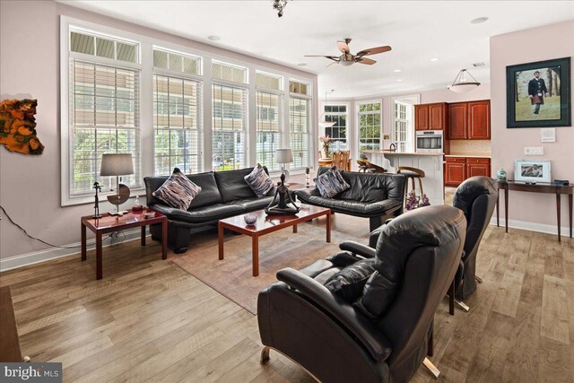 living room featuring light hardwood / wood-style flooring and ceiling fan