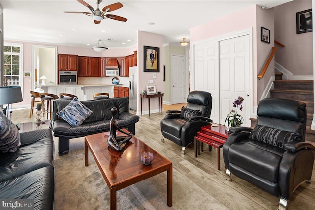 living room featuring ceiling fan and light hardwood / wood-style floors