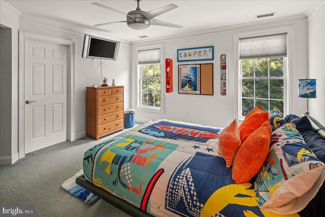 carpeted bedroom with ornamental molding and ceiling fan