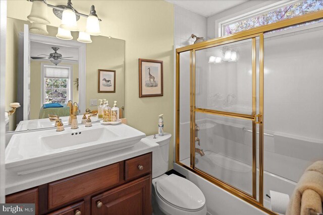 full bathroom featuring ceiling fan, vanity, shower / bath combination with glass door, and toilet