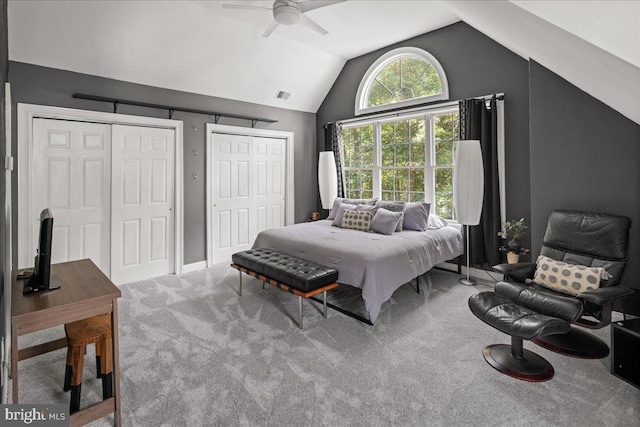 carpeted bedroom with lofted ceiling, ceiling fan, and multiple closets